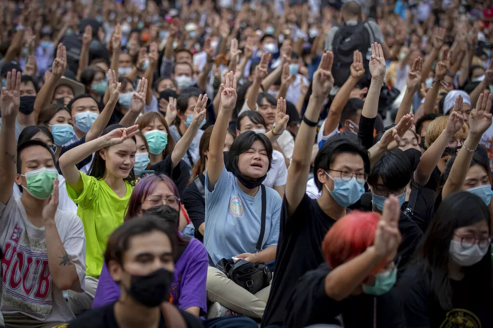 Manifestantes protestando contra o governo da Tailândia em 2020, usando o símbolo de Jogos Vorazes