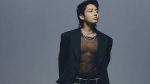Jungkook para a divulgação da música Seven, ele está usando diversos colares, uma blusa transparente e um blazer preto